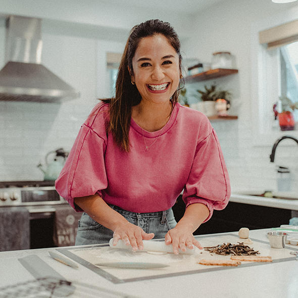 April Juiian smiling with hands on a rolling pin